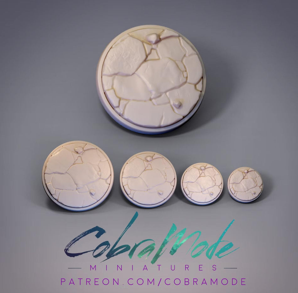 a collection of five circular objects with a cracked or textured appearance, arranged in a row against a gray background.